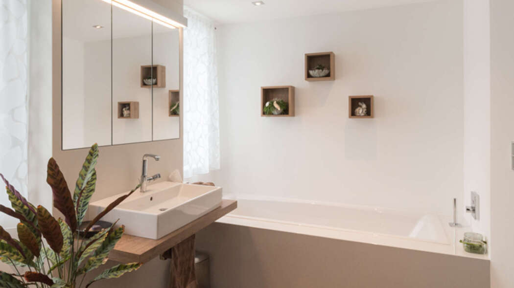 Badezimmer mit hellen Fliesen und Holzboden.